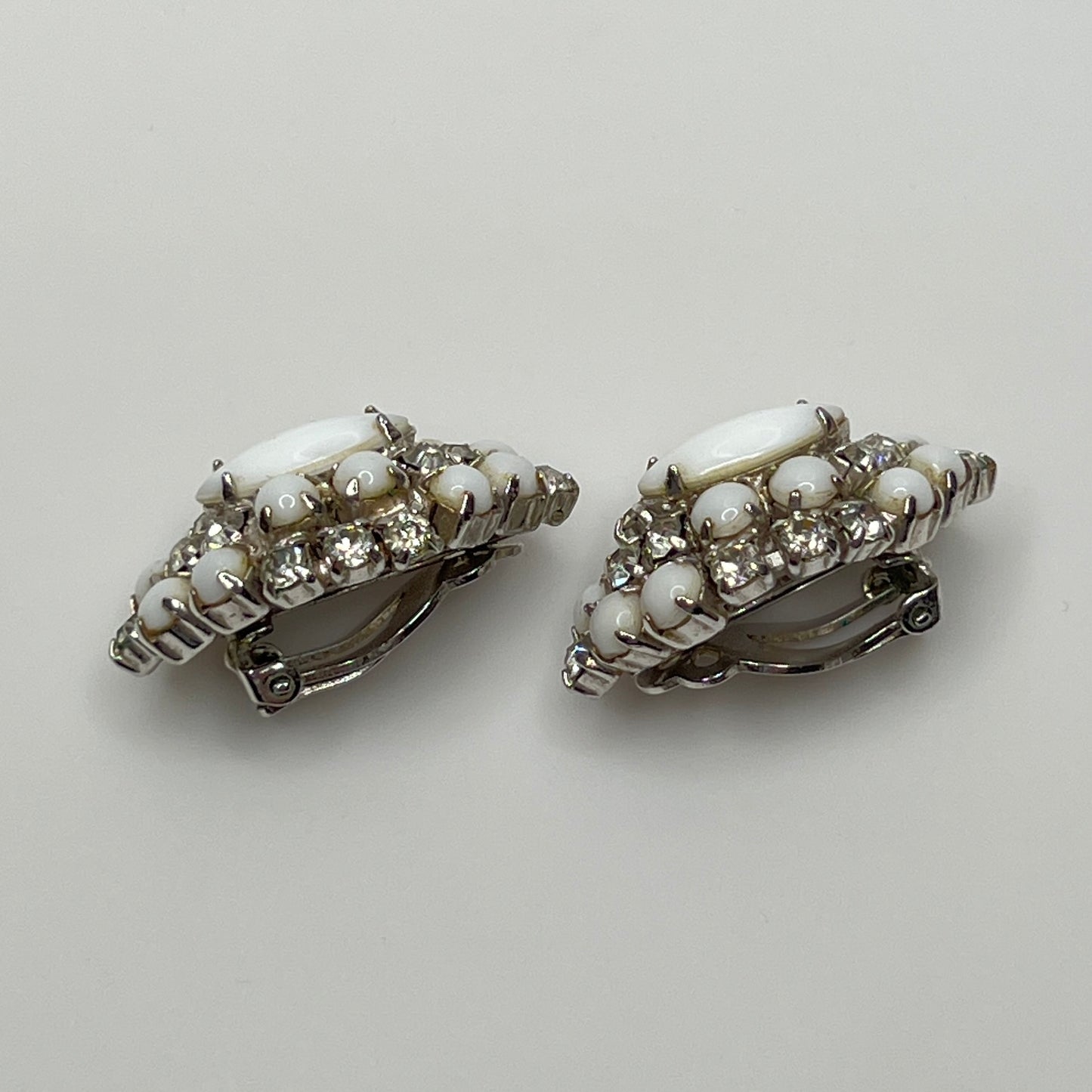 White vintage clip earrings with clear rhinestones and oval centers