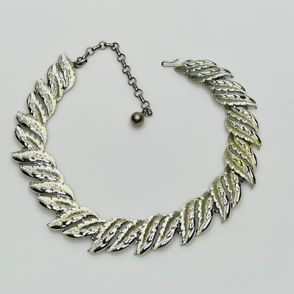 Mid-century silver-tone choker necklace with sculpted leaf links and hook extender clasp.
