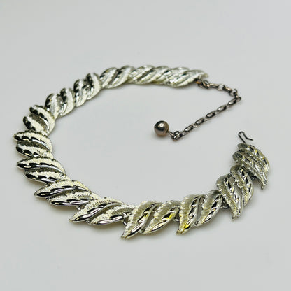 Mid-century silver-tone choker necklace with sculpted leaf links and hook extender clasp.