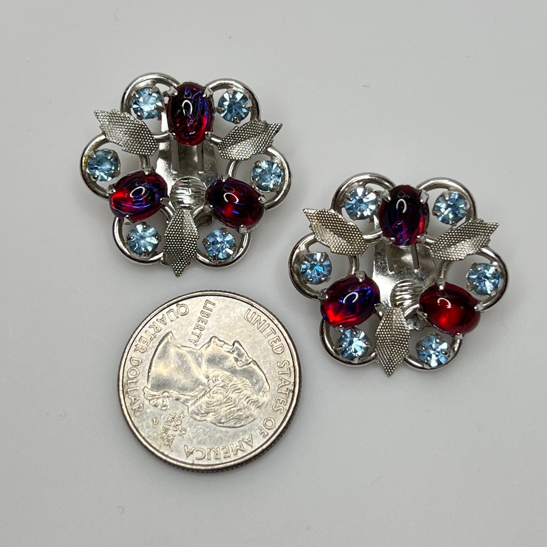 Vintage clip-on earrings with light blue rhinestones and red glass cabochons