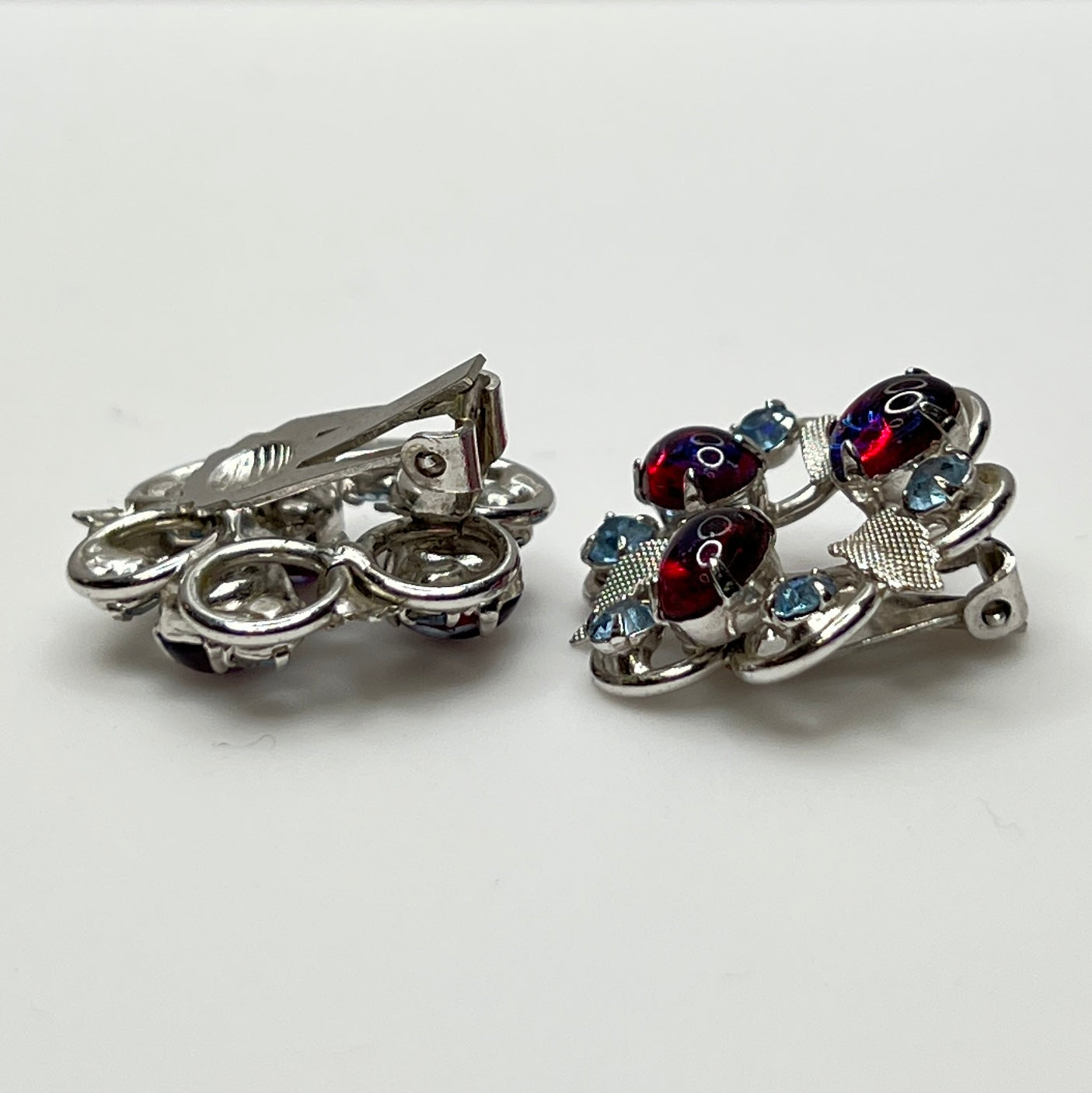 Vintage clip-on earrings with light blue rhinestones and red glass cabochons