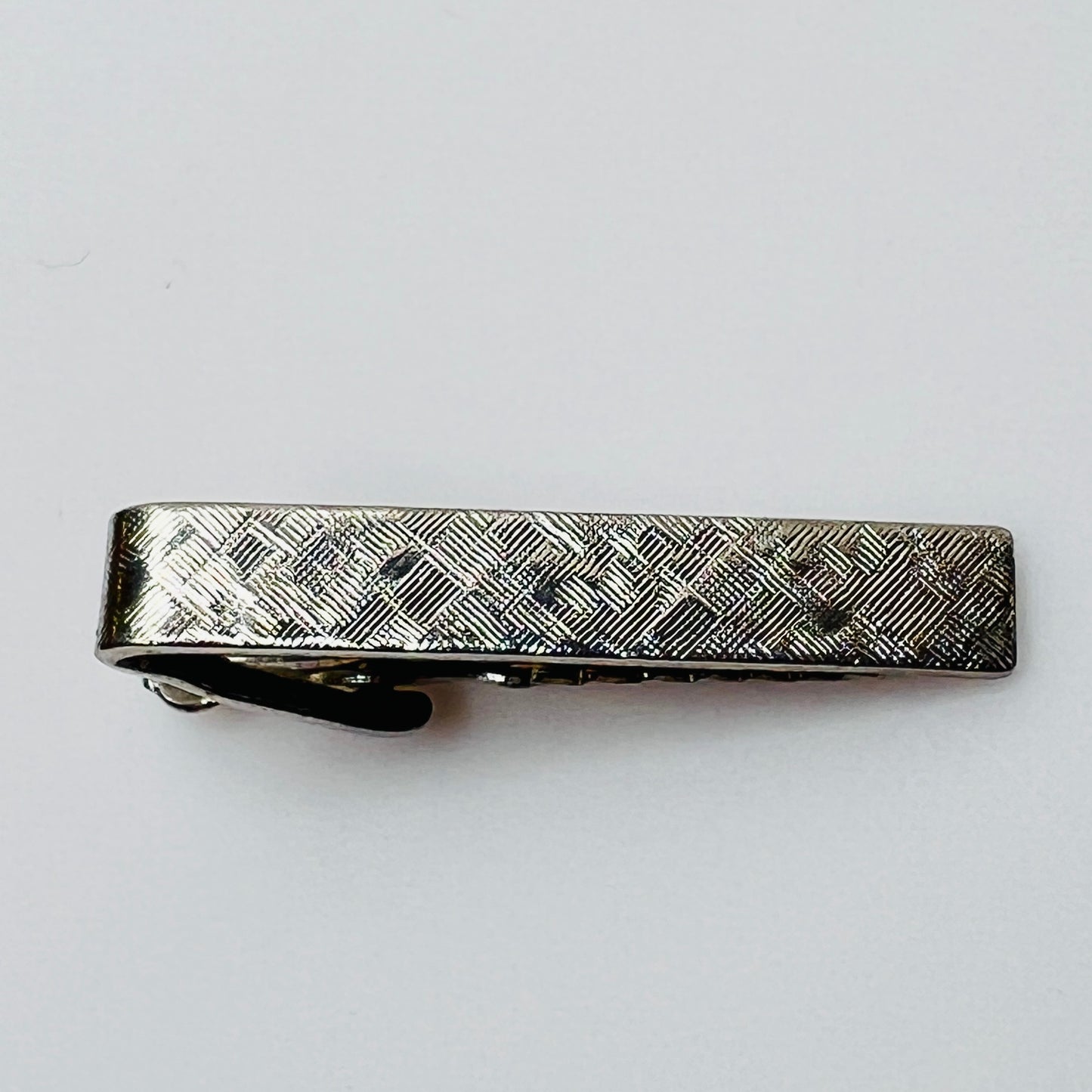 Vintage silver tie clip with crosshatch textured finish, shown front view