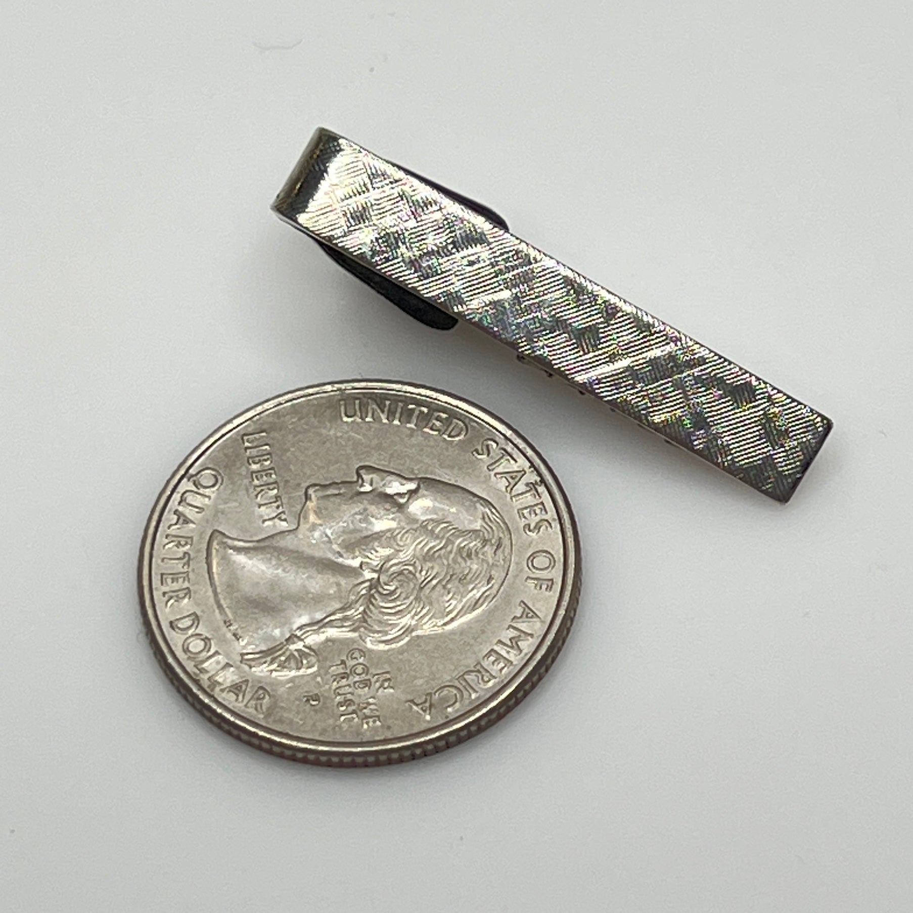 Vintage silver tie clip with crosshatch textured finish, shown front view