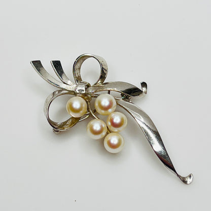 Close-up of lustrous Akoya pearls on sterling silver Mikimoto pin