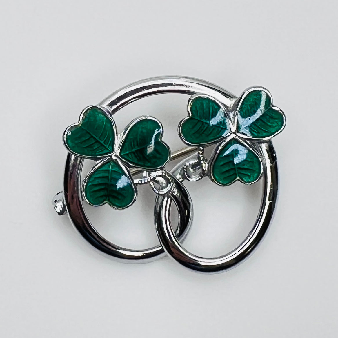 Silver tone double shamrock brooch with green enamel leaves