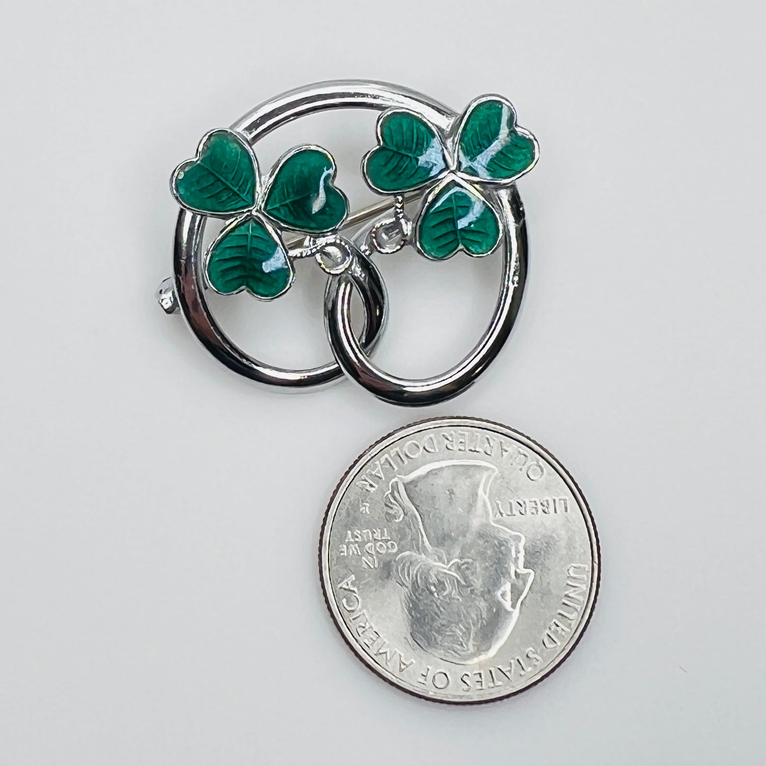 Silver tone double shamrock brooch with green enamel leaves