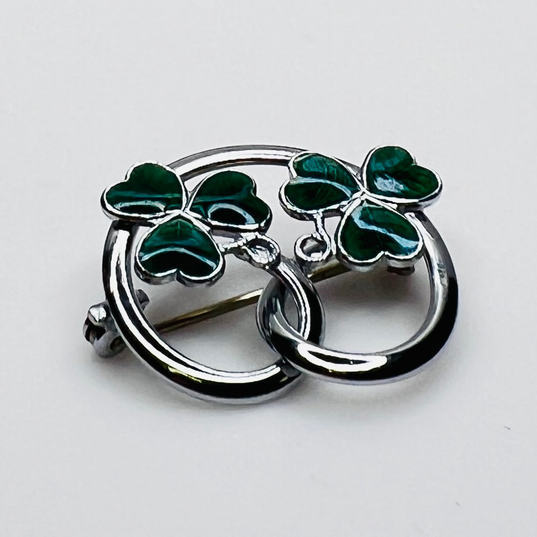 Silver tone double shamrock brooch with green enamel leaves