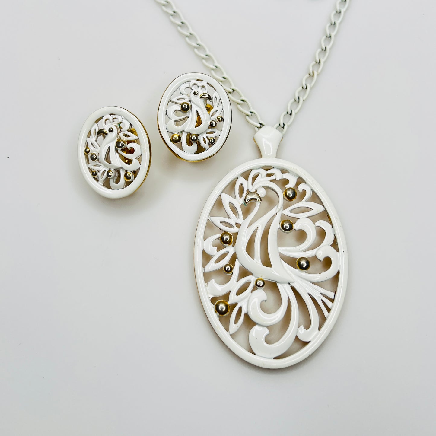 White enamel Monet jewelry set with bird of paradise motif clip-on earrings and pendant necklace