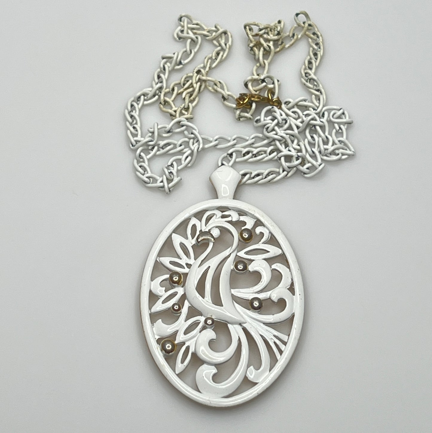 Close-up of pendant and chain showing vintage wear on enamel near clasp