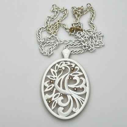 Close-up of pendant and chain showing vintage wear on enamel near clasp