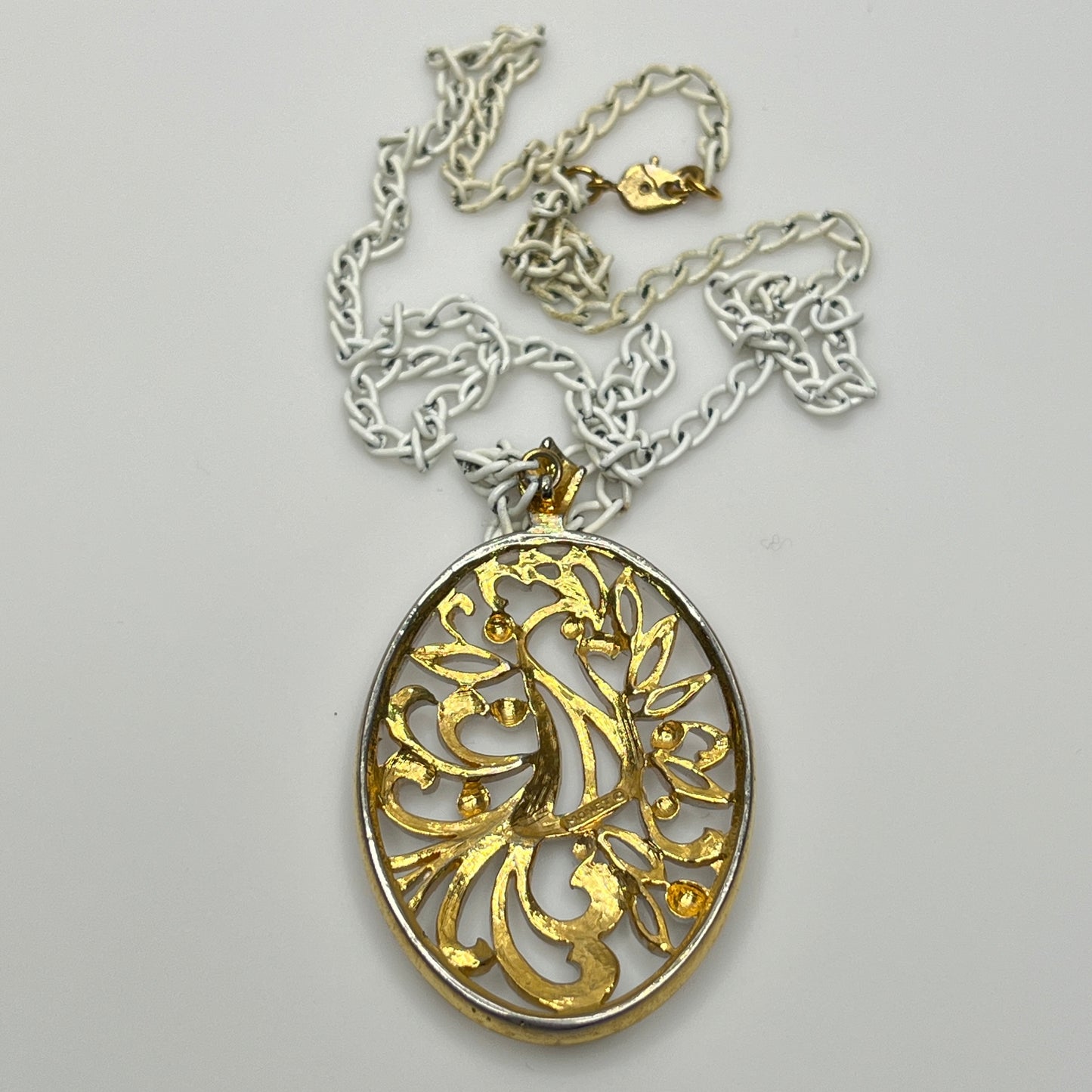 Close-up of pendant and chain showing vintage wear on enamel near clasp