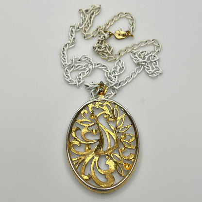 Close-up of pendant and chain showing vintage wear on enamel near clasp