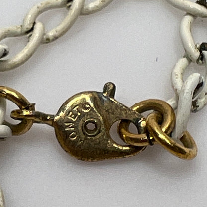 Close-up of pendant and chain showing vintage wear on enamel near clasp