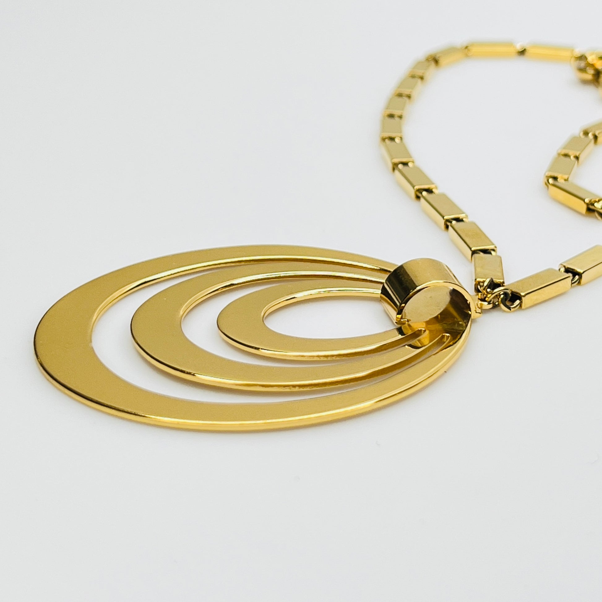 Side view of layered goldtone ovals on vintage Monet necklace