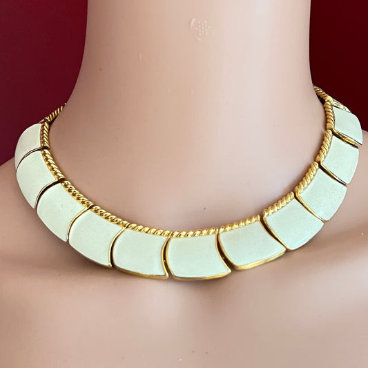 Close-up of enamel and gold tone links with rope detailing