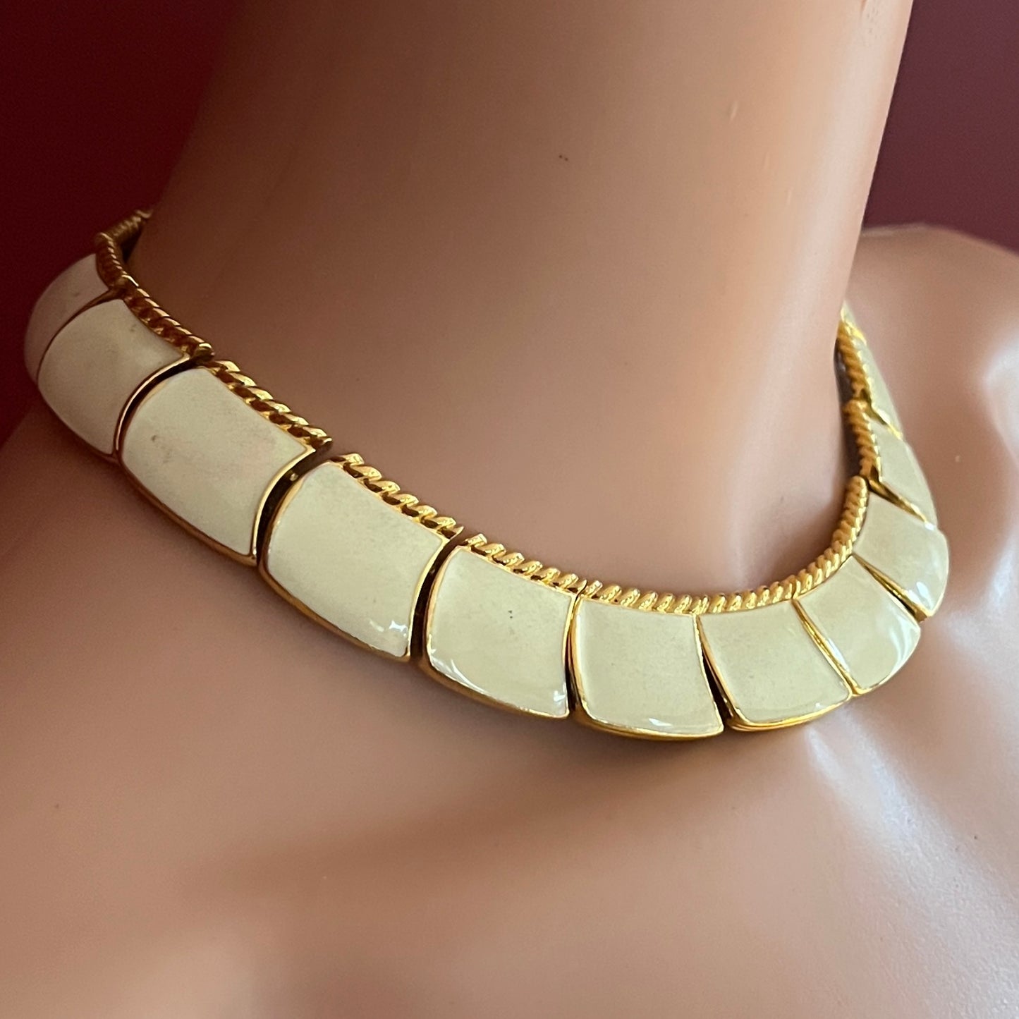 Close-up of enamel and gold tone links with rope detailing