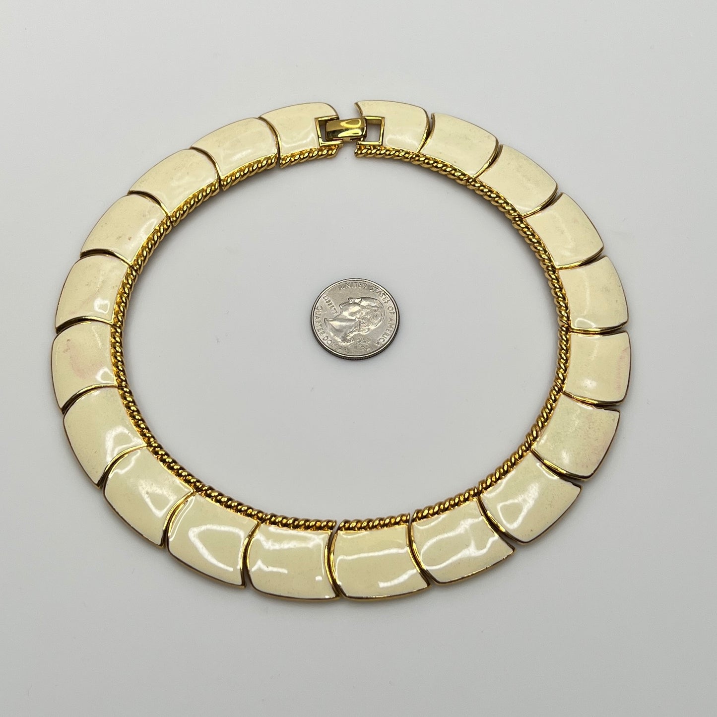 Close-up of enamel and gold tone links with rope detailing