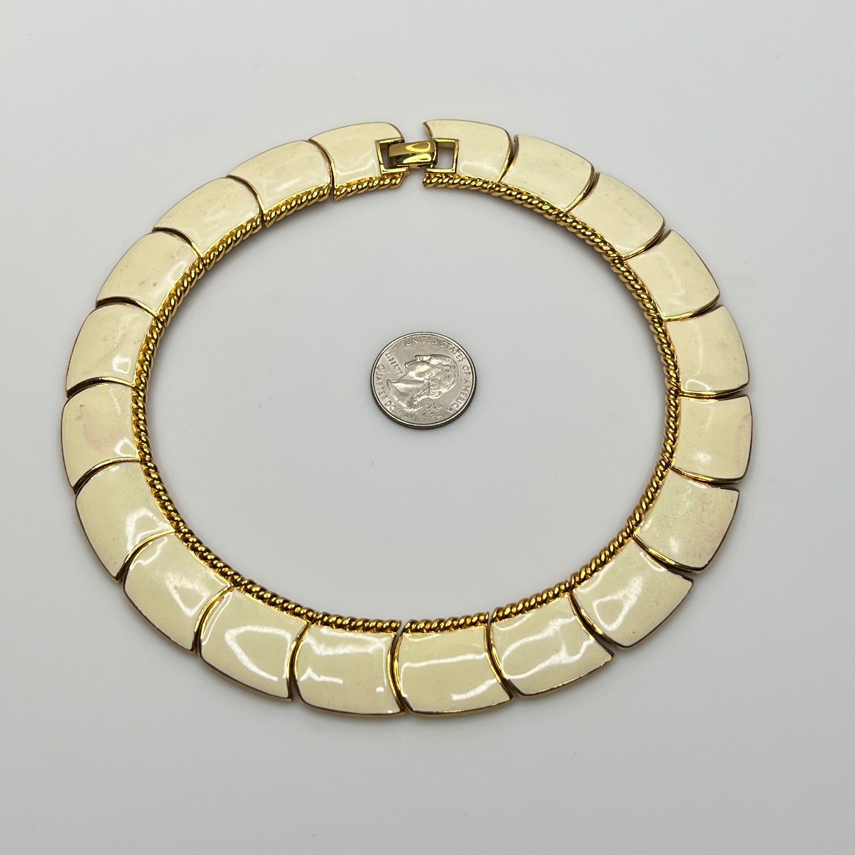 Close-up of enamel and gold tone links with rope detailing