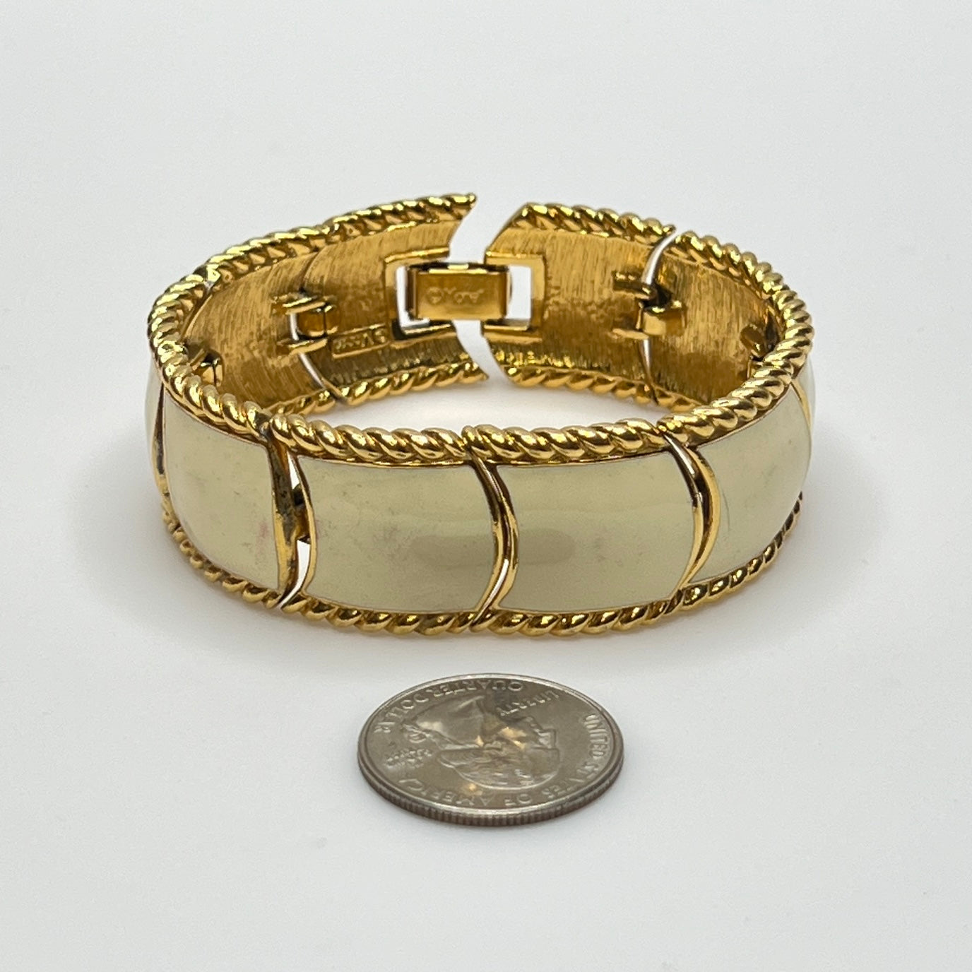 Close-up of enamel and gold tone links with rope detailing