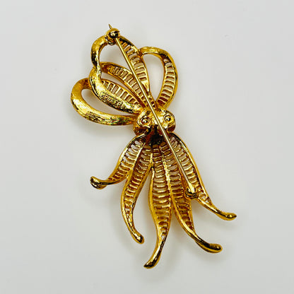 back view of dimensional gold ribbon brooch with textured detailing