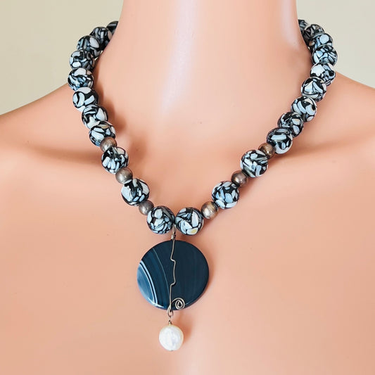 Bold artisan necklace with blue agate pendant and black glass beads
