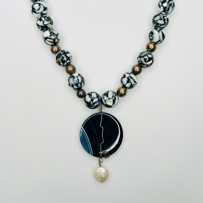 Bold artisan necklace with blue agate pendant and black glass beads