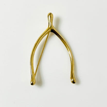 Vintage Napier gold-tone wishbone brooch with polished curved branches and softly rounded tips.