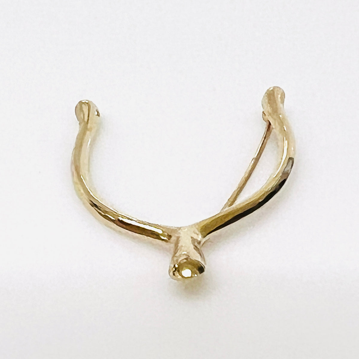 Angled view of the Napier wishbone brooch showing its rounded profile and polished gold-tone finish.