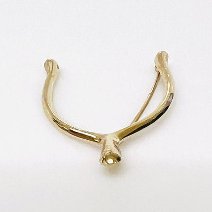 Angled view of the Napier wishbone brooch showing its rounded profile and polished gold-tone finish.