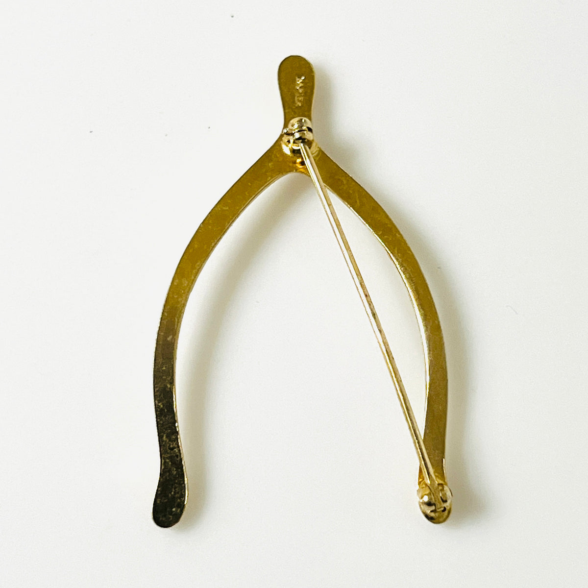 Reverse of gold-tone Napier wishbone brooch showing the long pin and clasp.