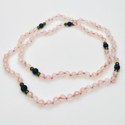Long artisan rose quartz necklace on display form