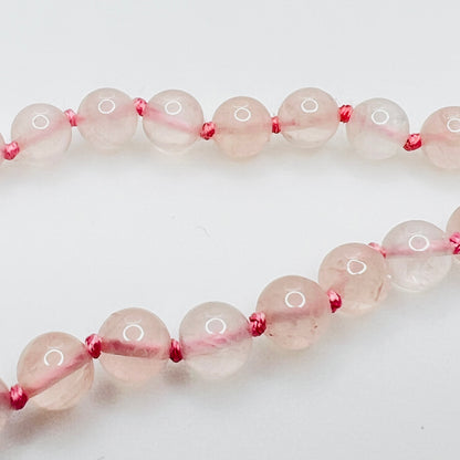 Close up of lapis and brass spacer beads with pink knotting