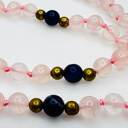 Close up of lapis and brass spacer beads with pink knotting