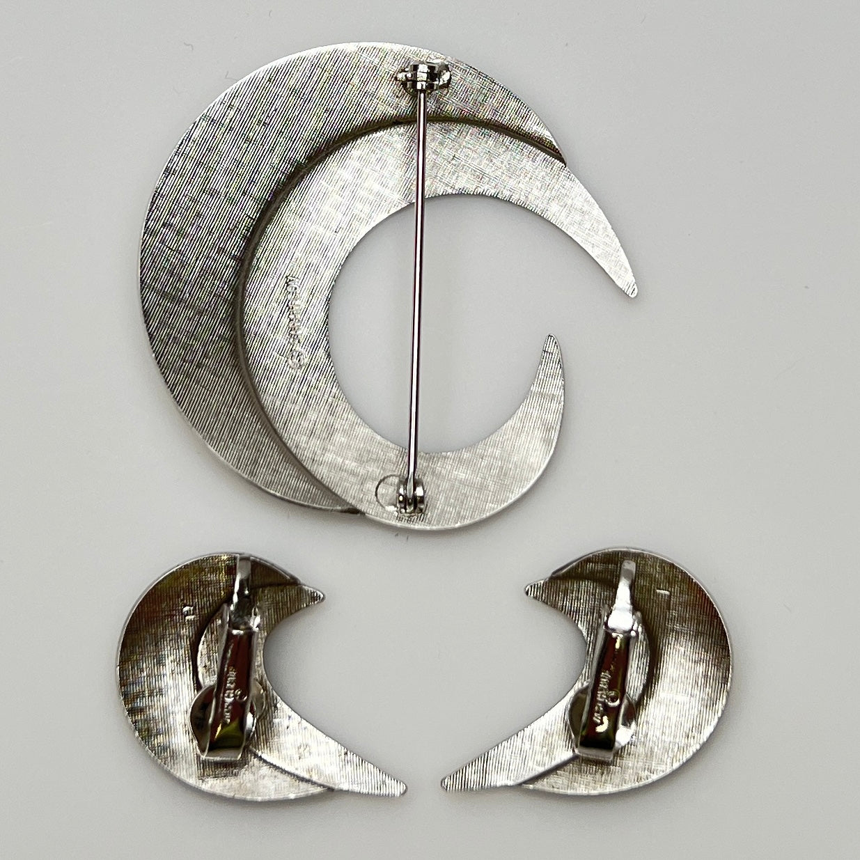 Close-up of sculptural crescent moon shapes in shiny silver finish