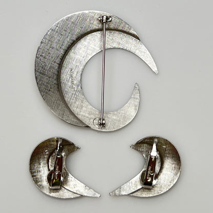 Close-up of sculptural crescent moon shapes in shiny silver finish