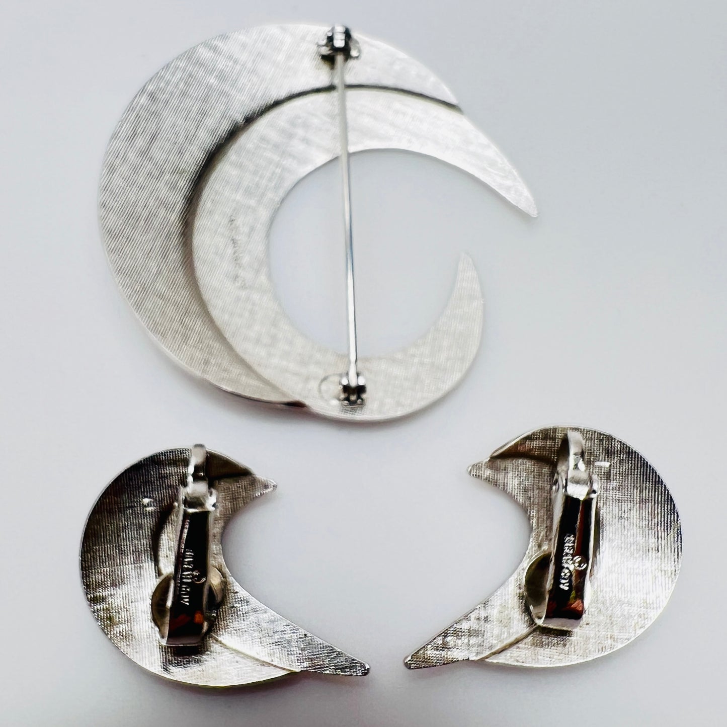 Close-up of sculptural crescent moon shapes in shiny silver finish