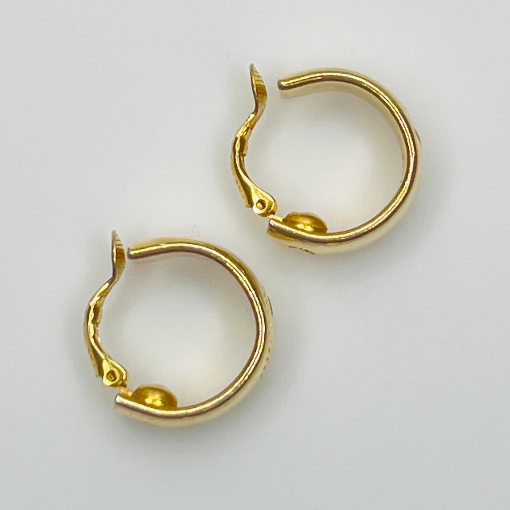 Side view Sarah Coventry gold-tone etched hoop earrings with leaf design