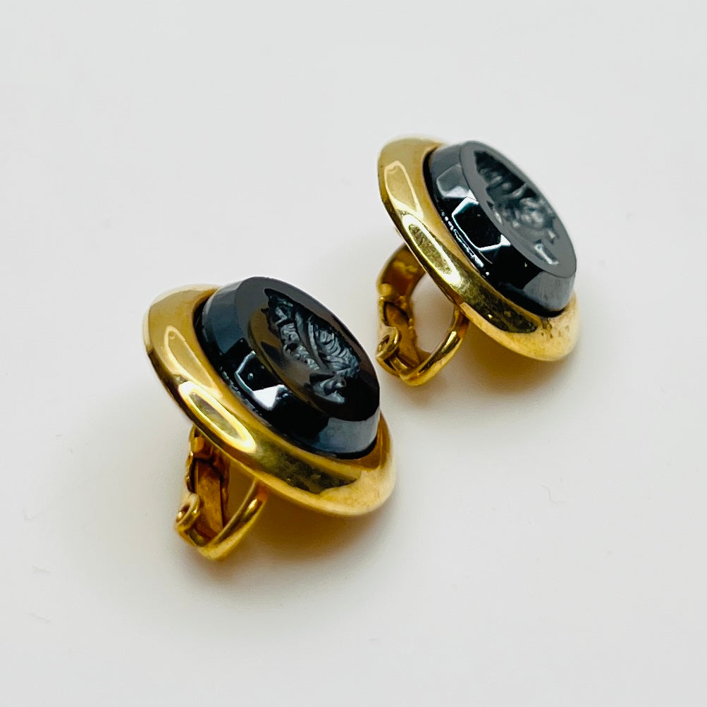 Side view of earrings showing raised gold-tone setting and secure clips