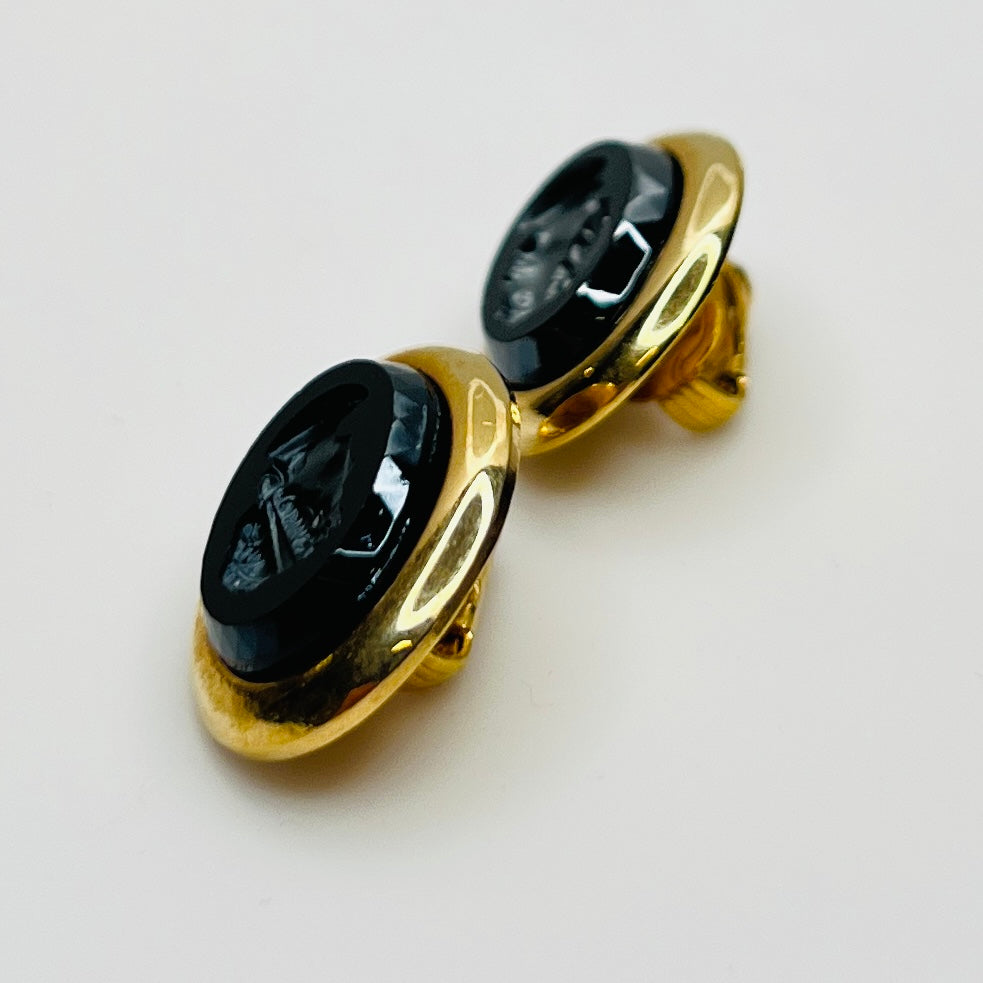 Side view of earrings showing raised gold-tone setting and secure clips