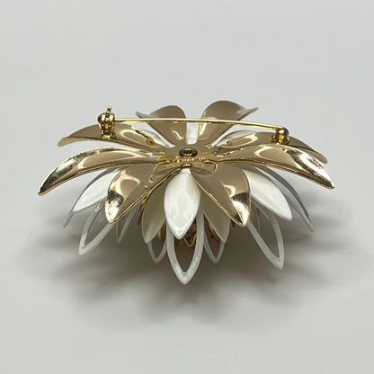 Close-up of white and gold enamel water lily brooch with layered petals
