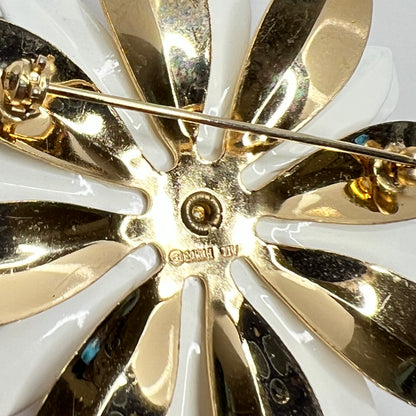 Close-up of white and gold enamel water lily brooch with layered petals