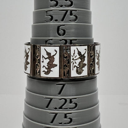 Close-up of white enamel bracelet with Thai goddess motifs