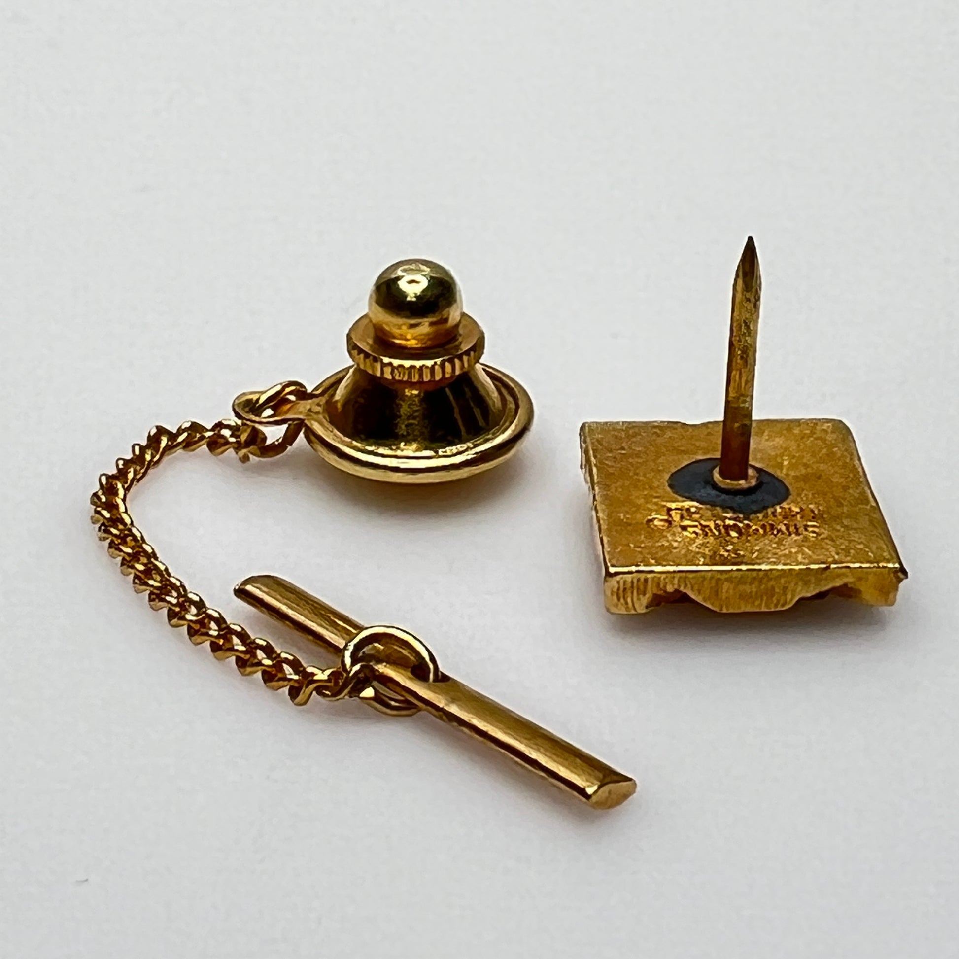 Vintage 1970s tie tack with geometric gemstone and etched gold border