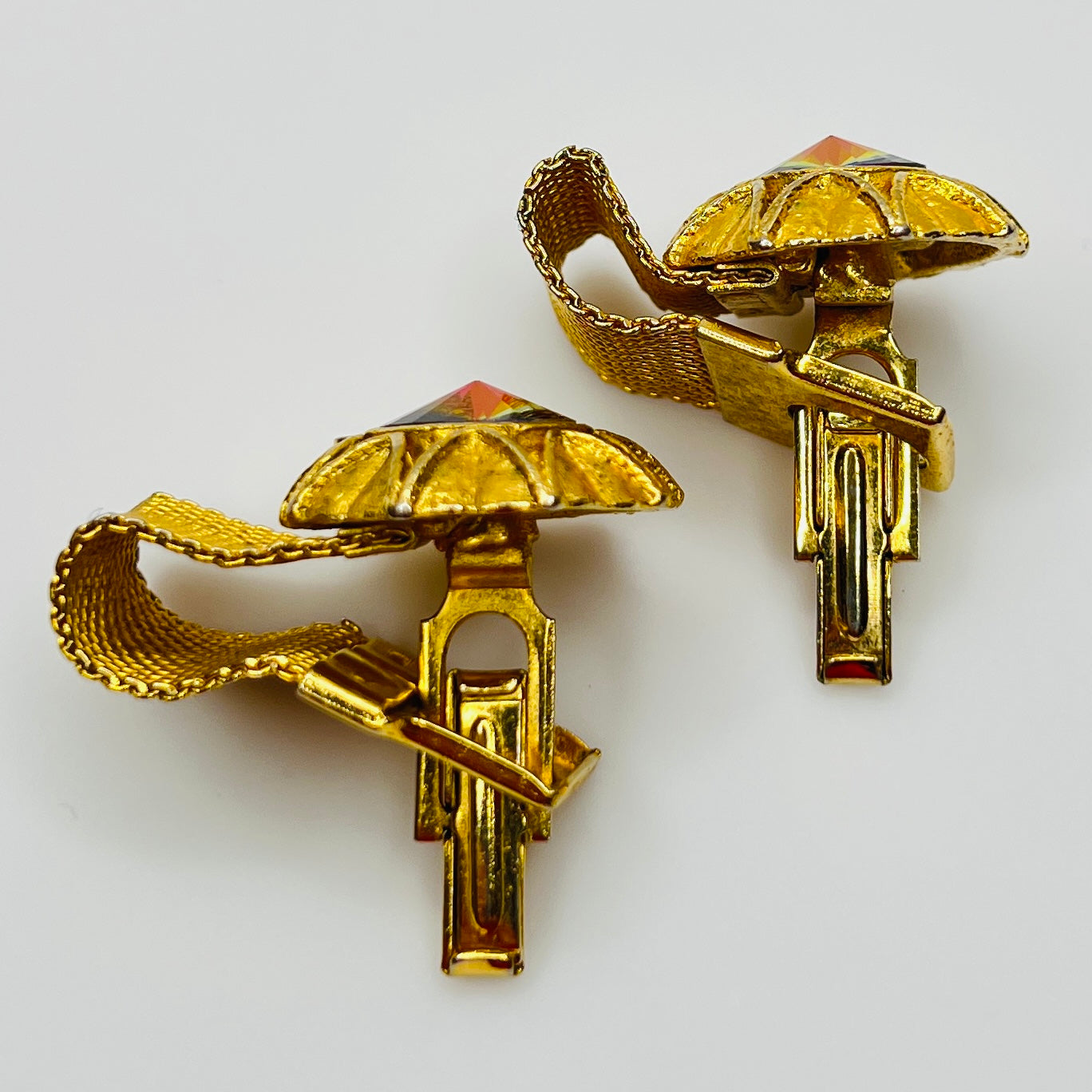 Close-up of round prismatic rivoli cufflink in gold-tone sunburst bezel