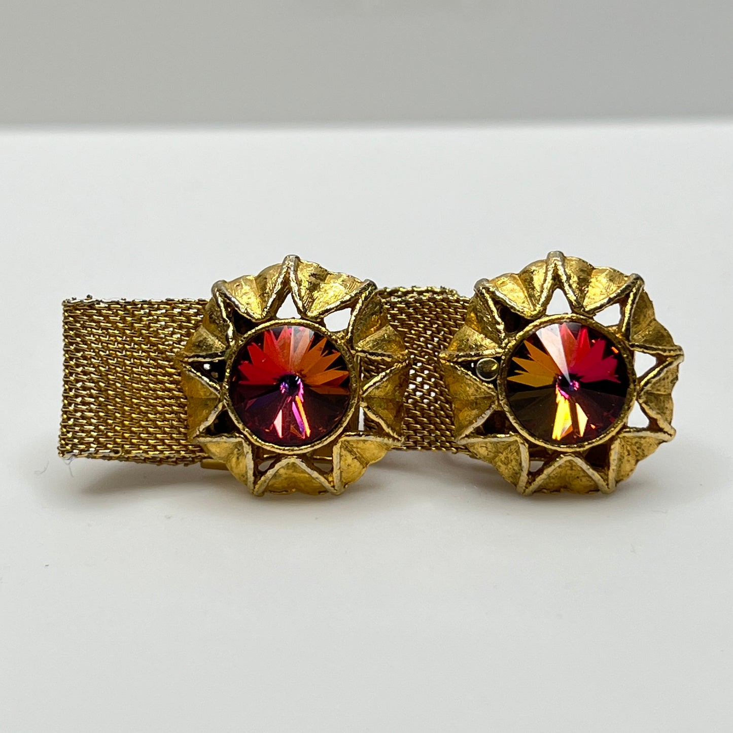 Close-up of round prismatic rivoli cufflink in gold-tone sunburst bezel