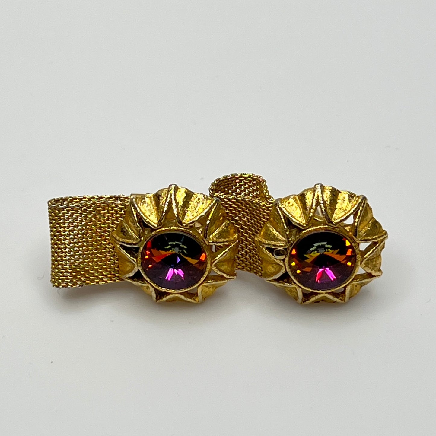 Close-up of round prismatic rivoli cufflink in gold-tone sunburst bezel
