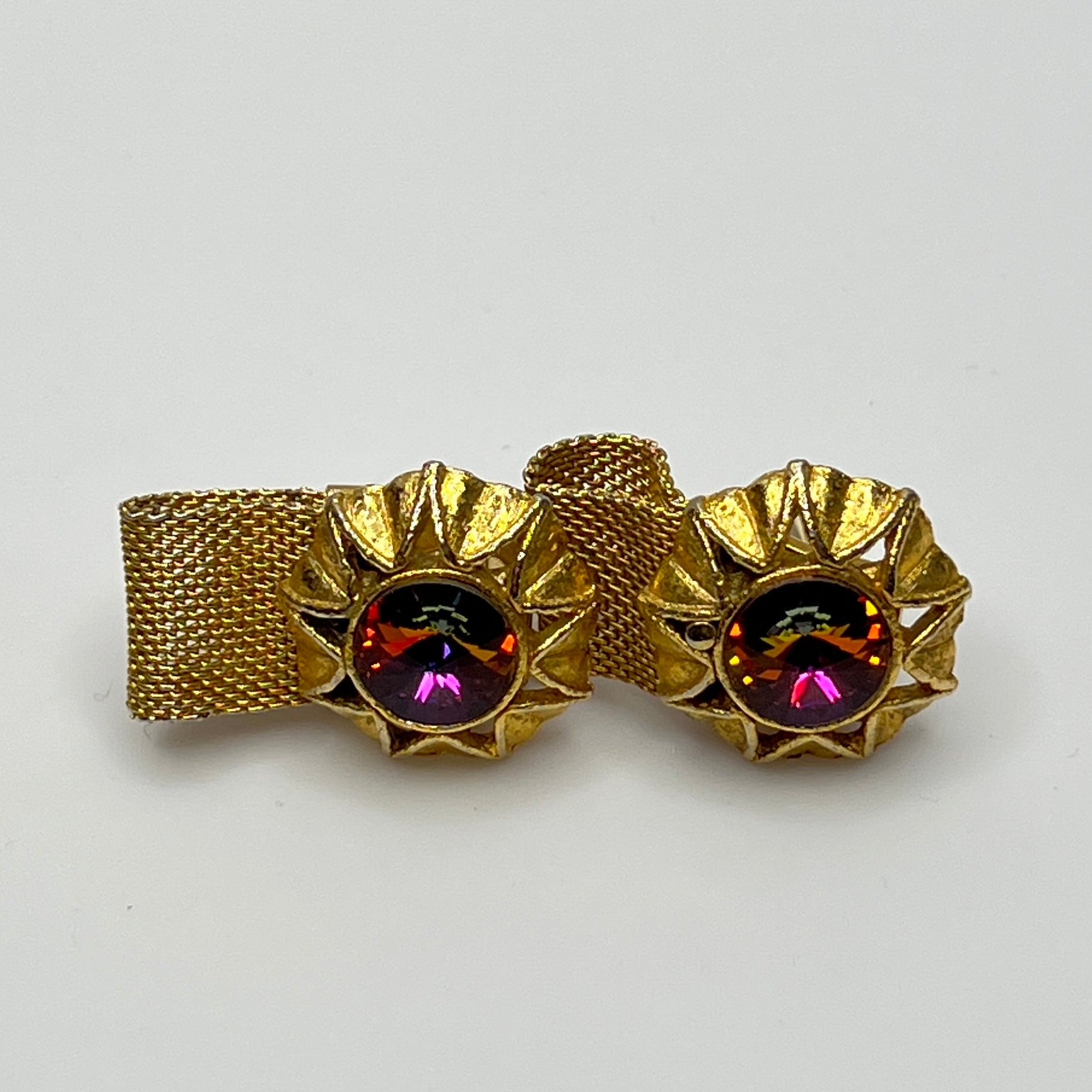Close-up of round prismatic rivoli cufflink in gold-tone sunburst bezel