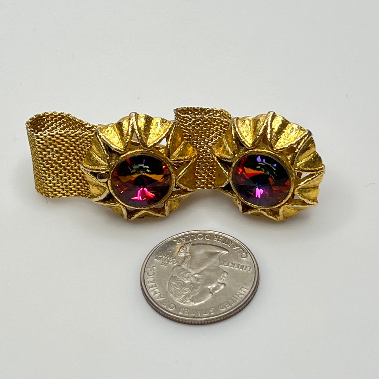Close-up of round prismatic rivoli cufflink in gold-tone sunburst bezel