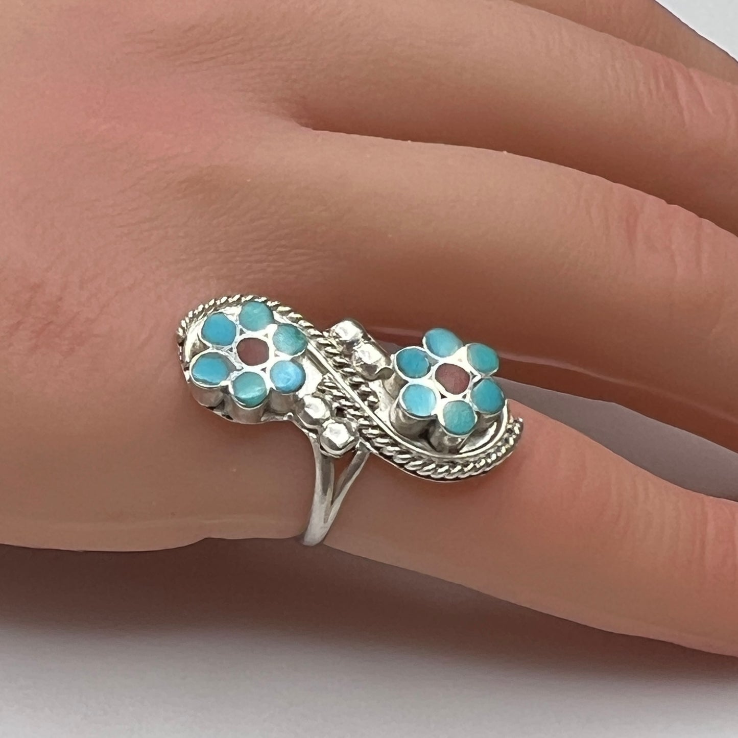 Sterling silver turquoise flower ring on hand, pinky fit with double floral design