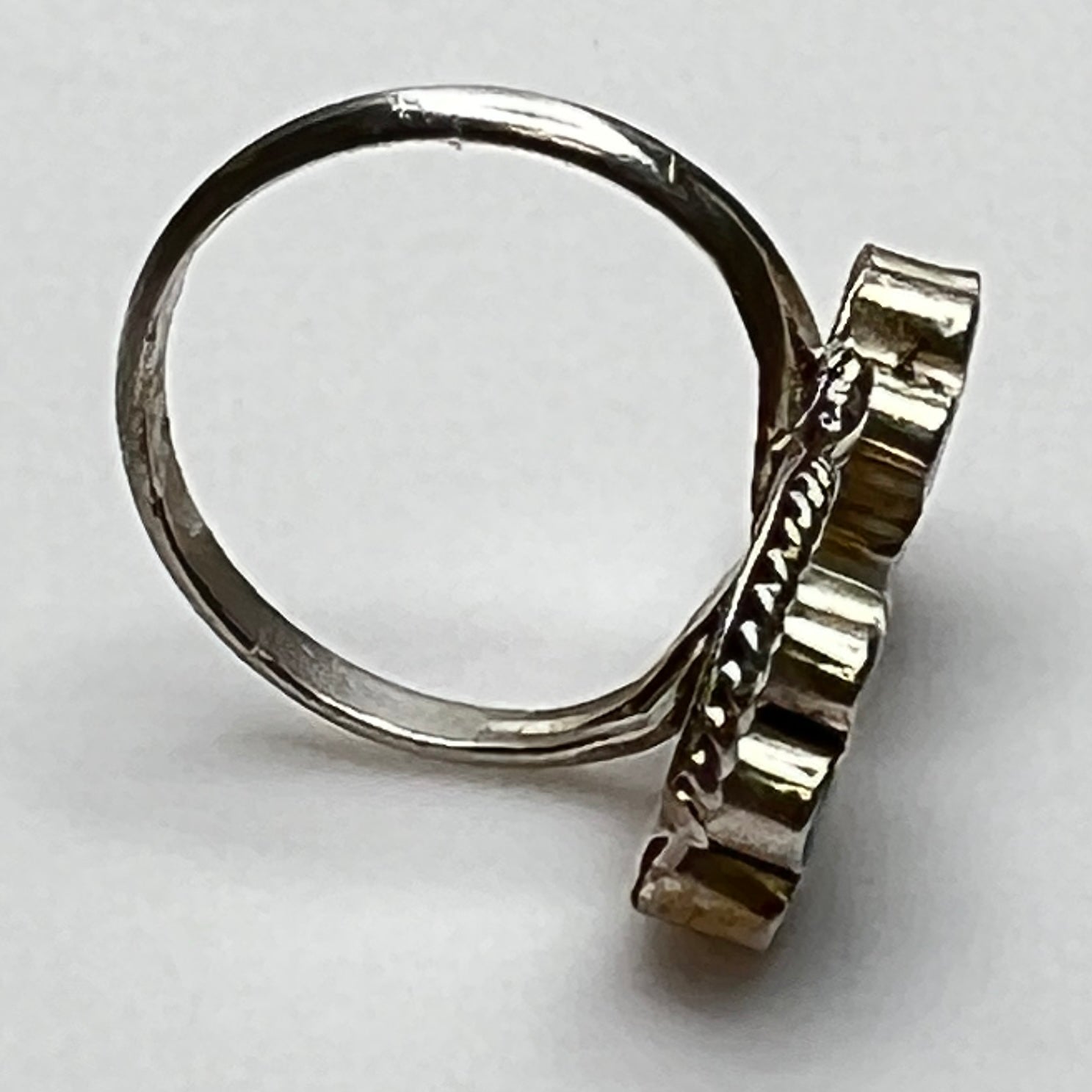 Side view of raised turquoise and red floral inlays in silver setting